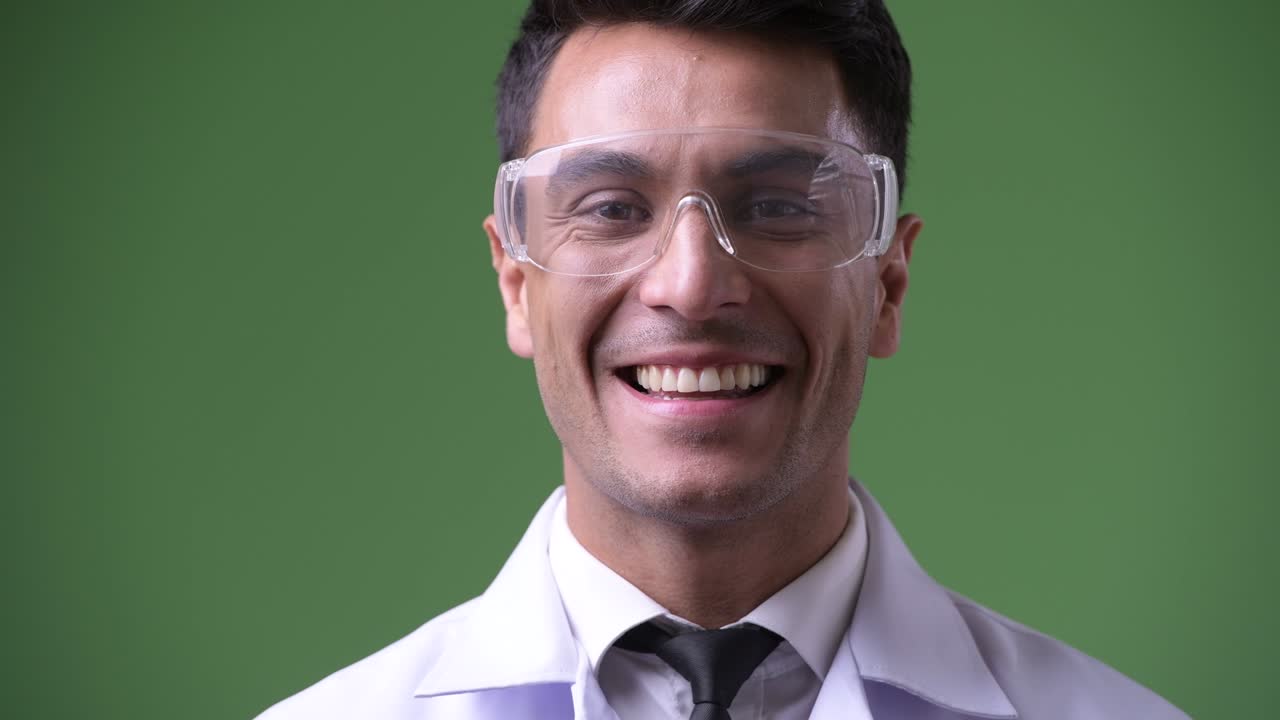 초록색 배경에 젊은 잘생긴 히스패닉 남자 의사