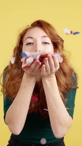 joyful woman blowing confetti