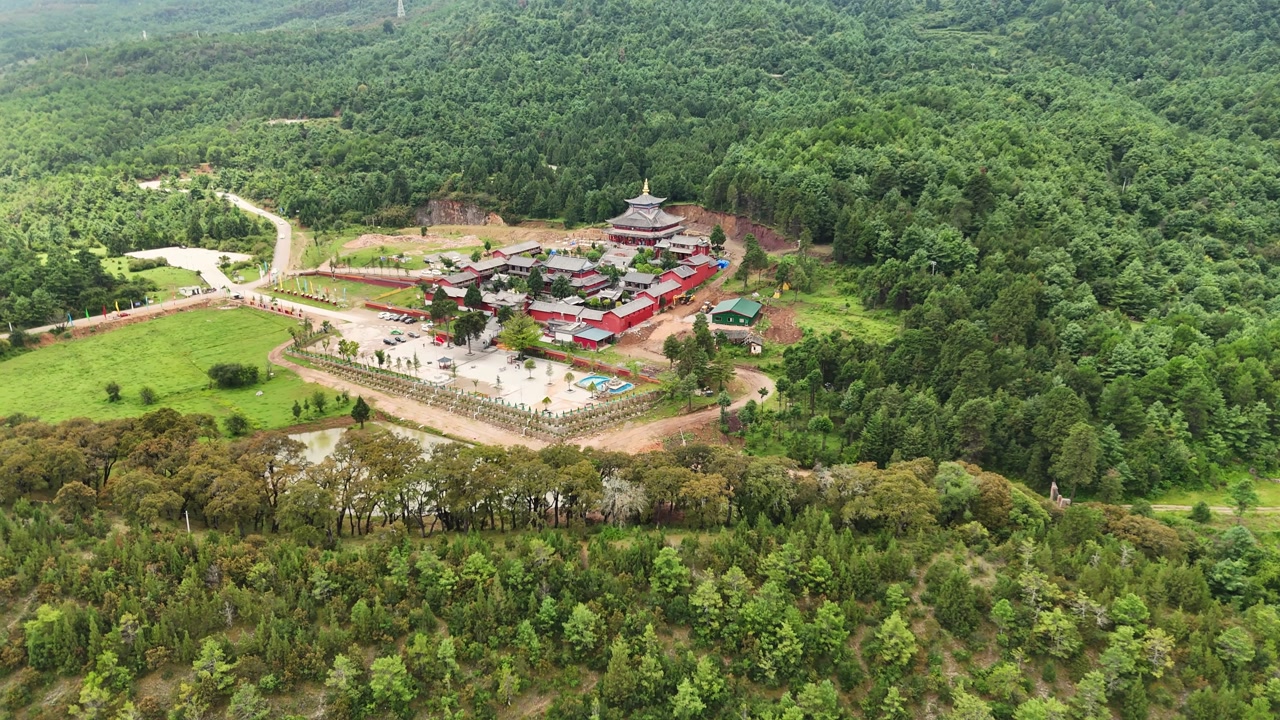 High angle aerial shot of the historic Fuguo Monastery and surrounding forest landscape in Yunnan. Perfect for travel documentaries and cultural heritage content.