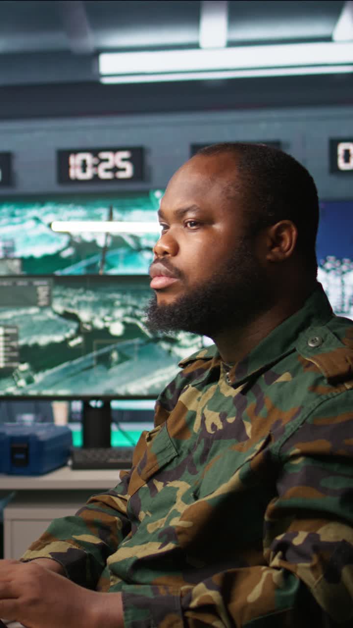Vertical video Man monitoring army HQ CCTV for any unauthorize activity