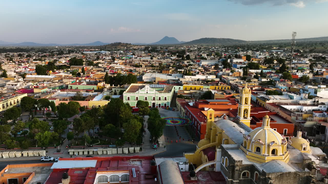 vista aérea hacia atrás sobre el parque juárez y el san luis obispo barroco, puesta de sol en huamantla, méxico