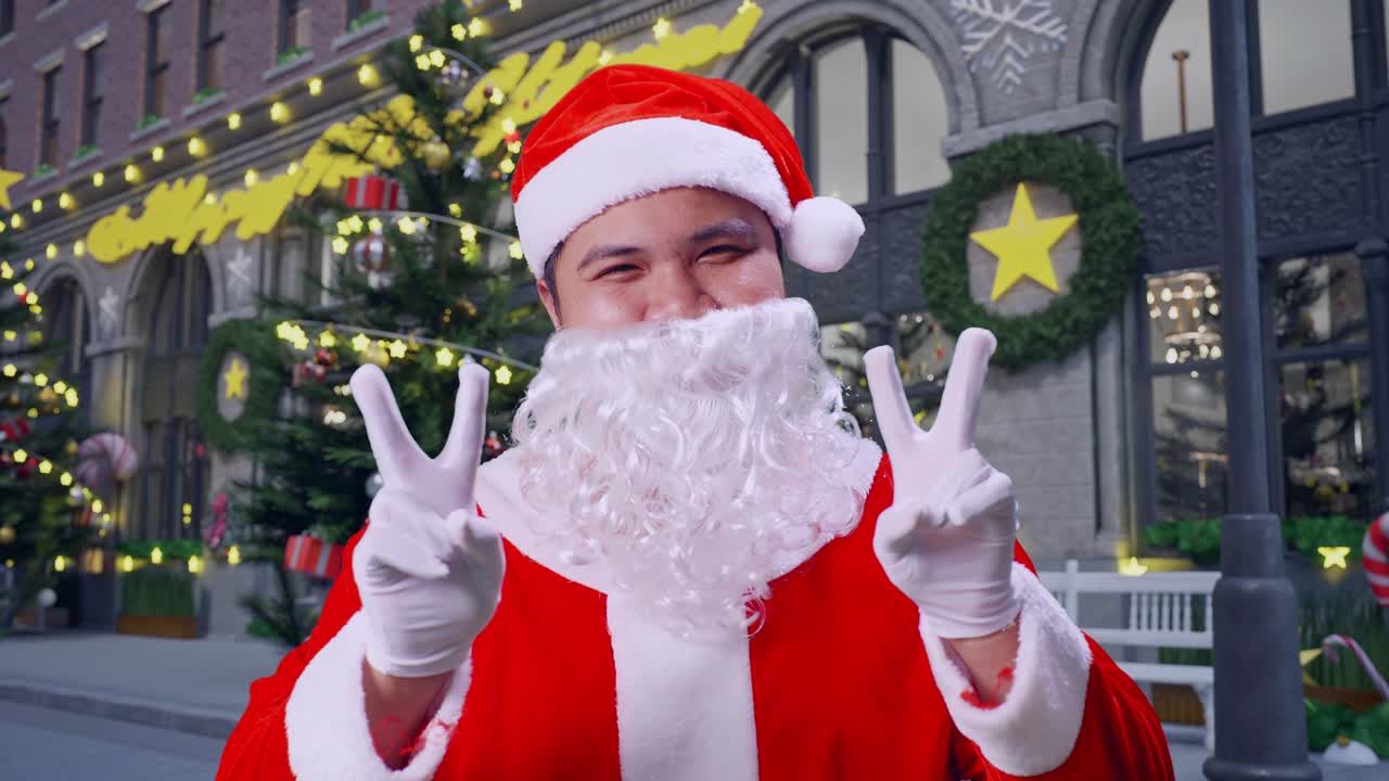 아시아 산타클로스가 크리스마스 밤에 서서 평화의 제스처를 보여주는 클로즈업