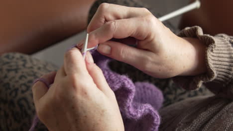 Close-up-of-hands-knitting-a-purple-piece