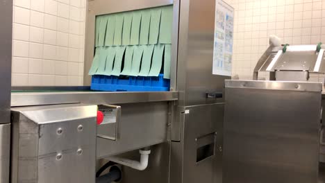 an empty basket coming out of an industrial dish washer