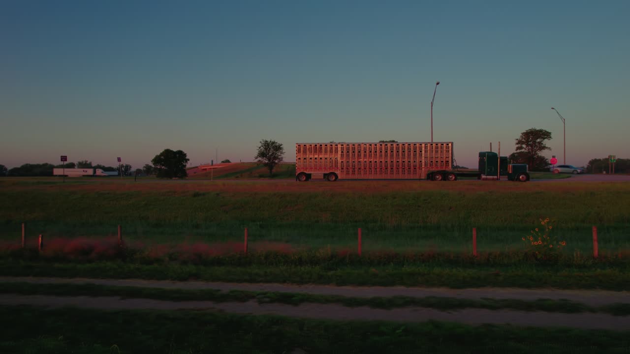 Aluminum livestock trailer “cattle pot” rolling past farmland at golden hour. Ideal B-roll for ranching, agriculture, animal transport, or rural infrastructure themes