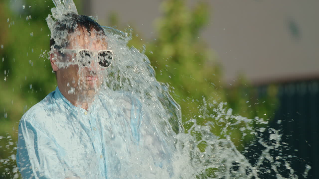 hombre siendo salpicado con agua en el verano