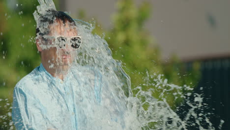 man getting splashed with water in the summer