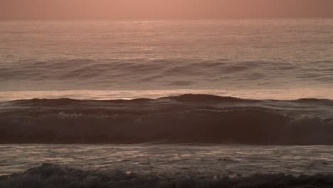 close up waves rolling on the beach in the golden sunset light