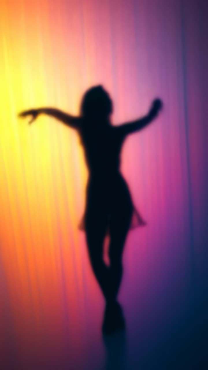 Silhouette of a dancer in motion against a vibrant, colorful backdrop