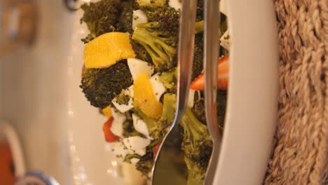 broccoli and fruit salad with tongs