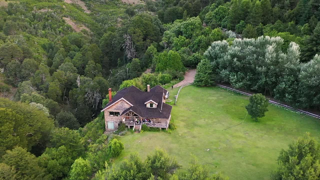 슬로우 모션 60fps로 녹화된 초목 산 한가운데 있는 꿈결 같은 나무와 석조 집