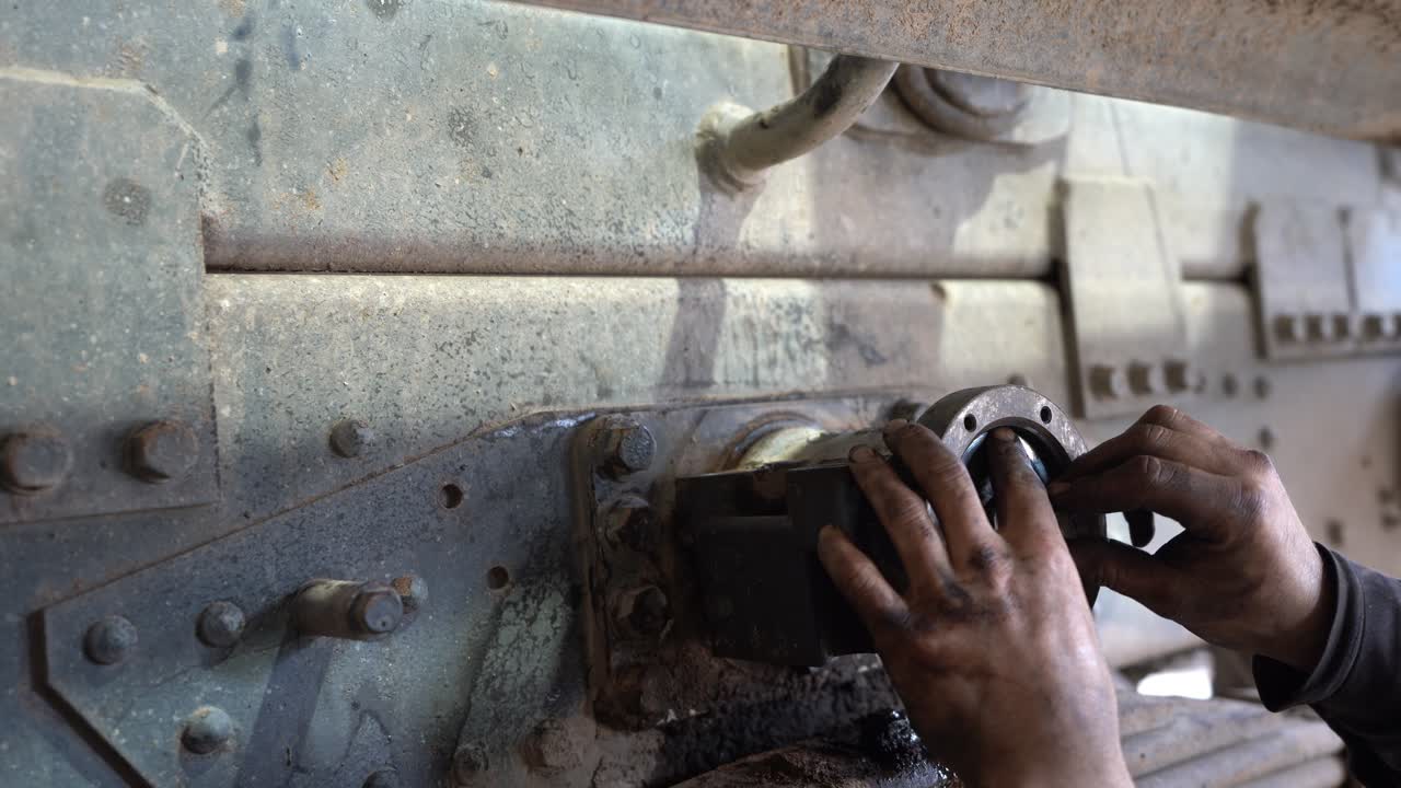 un mecánico está trabajando en una suspensión trasera de un vehículo pesado