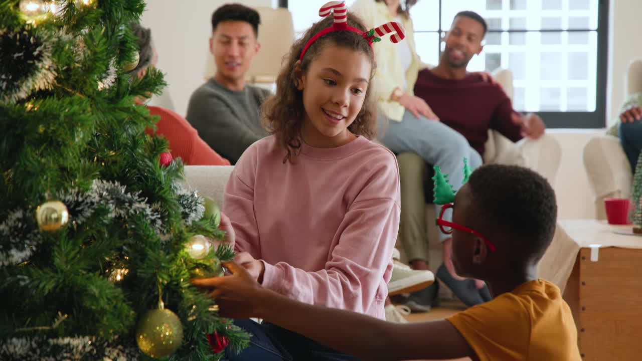 Siblings and family decorating christmas tree together, sharing joyful moments at home