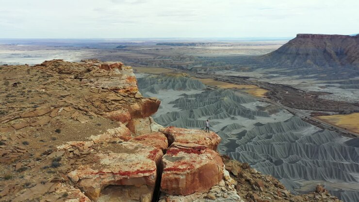 Uomo in piedi su una roccia sopra un abisso e il paesaggio desertico dello Utah, USA, vista aerea