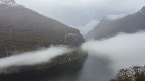 Zeitraffer-Des-Geiranger-Fjords-In-Norwegen-Mit-Bewölktem-Himmel-Und-Wolken,-Die-Die-Berge-Bedecken