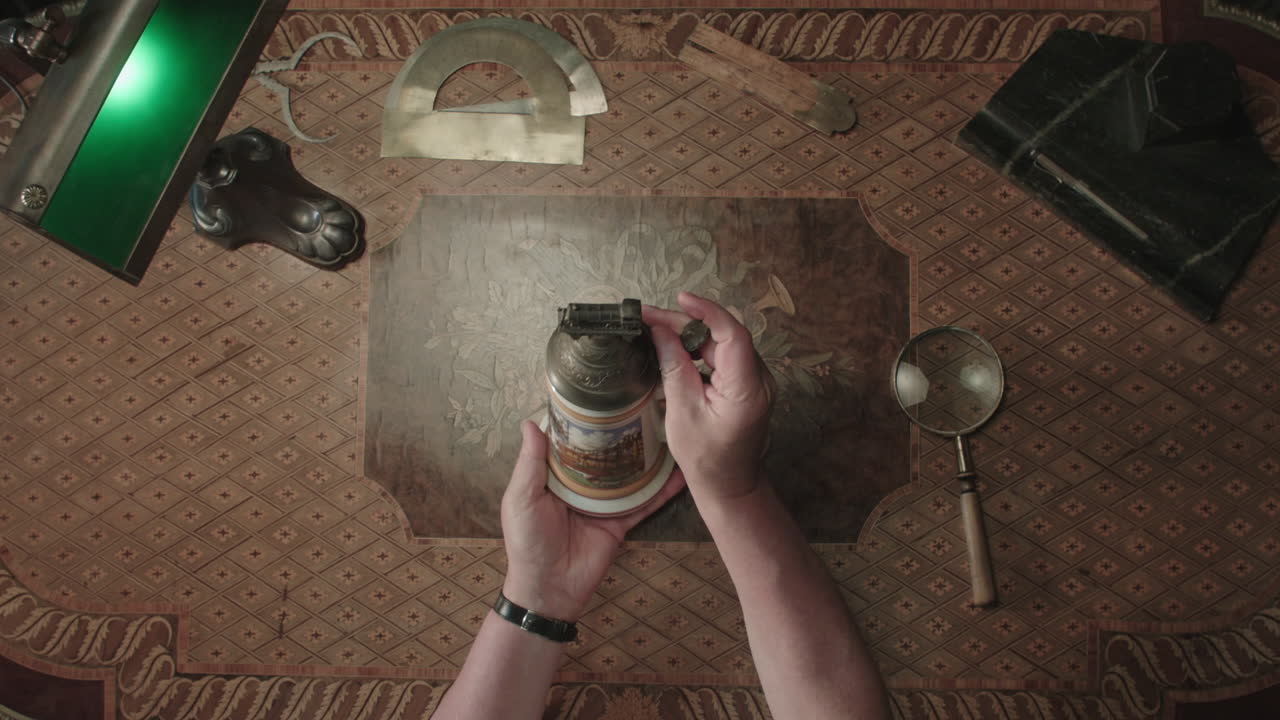 An older man evaluates an antique beer mug