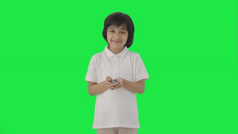 Happy-Indian-boy-holding-lot-of-coins-in-hand-Green-screen