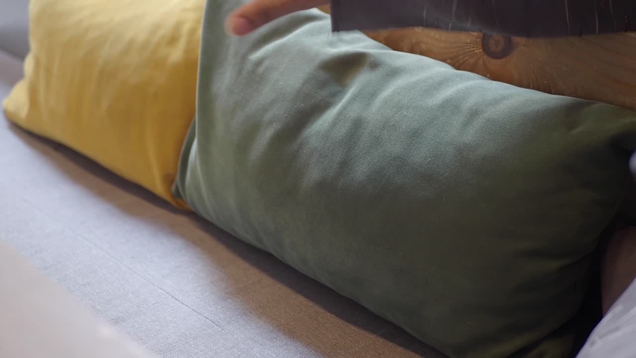 Close-up of pillows and hand