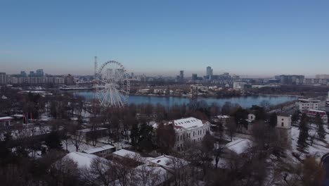 aerial of ferris wheel, park and a lake at winter