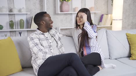 Smiling-diverse-young-couple-spending-time-with-each-other-at-home,-holding-hands.