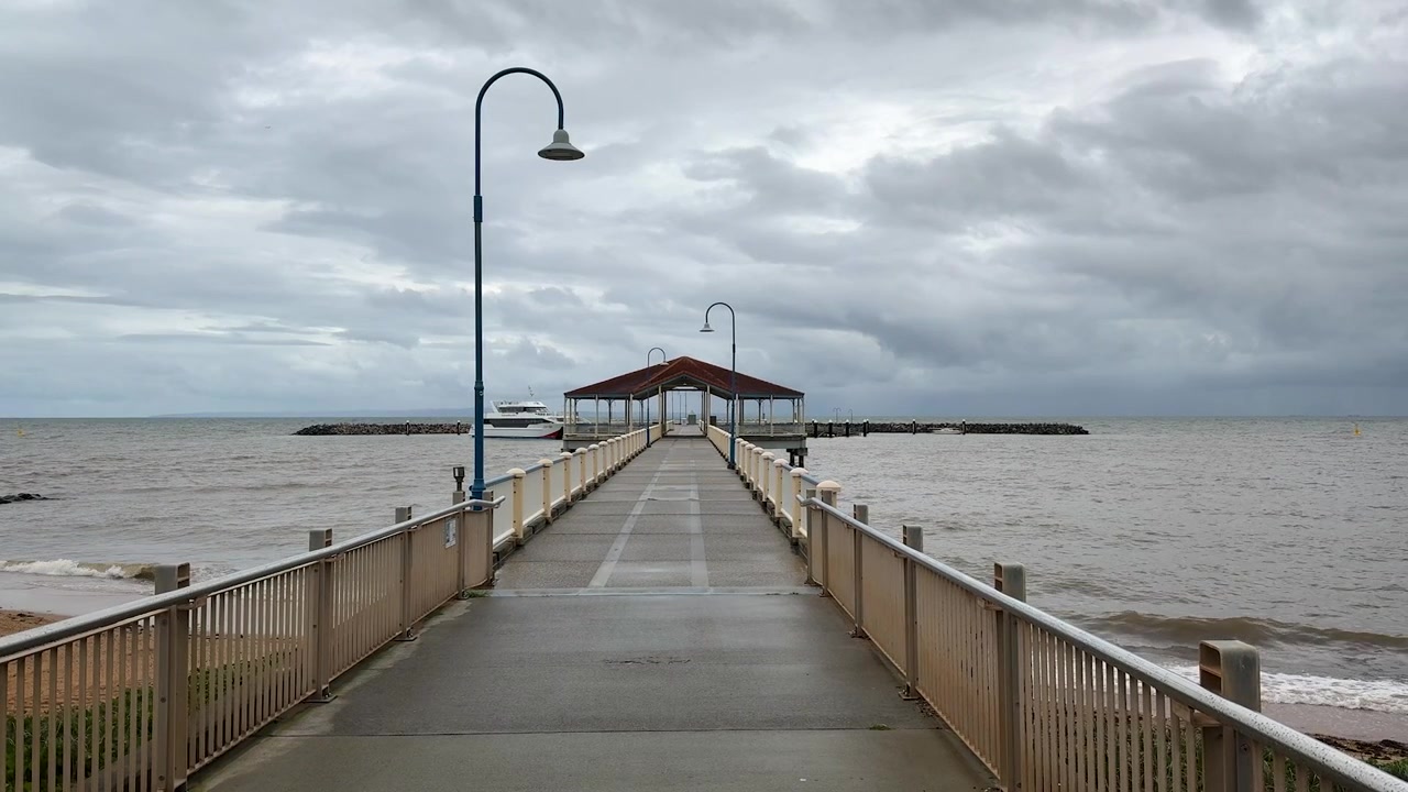 Pemandangan luas di sepanjang Dermaga Redcliffe pada hari yang mendung dan berawan. Queensland, Australia