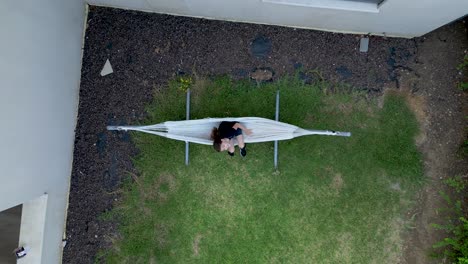 4k high resolution drone video of the a young girl enjoying a hammock during summer vacation in northern israel