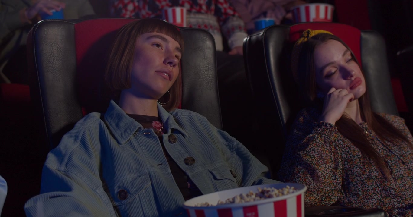Jovens mulheres entediadas e adormecendo no cinema