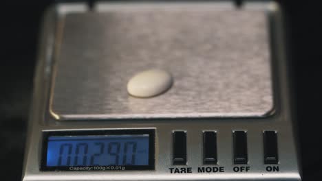 weighing a small pearl-like object on a digital scale