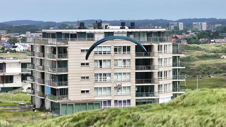 Parapendio sopra un condominio in una città costiera