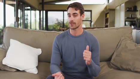 portrait of caucasian man talking looking that camera sitting on the couch at vacation home