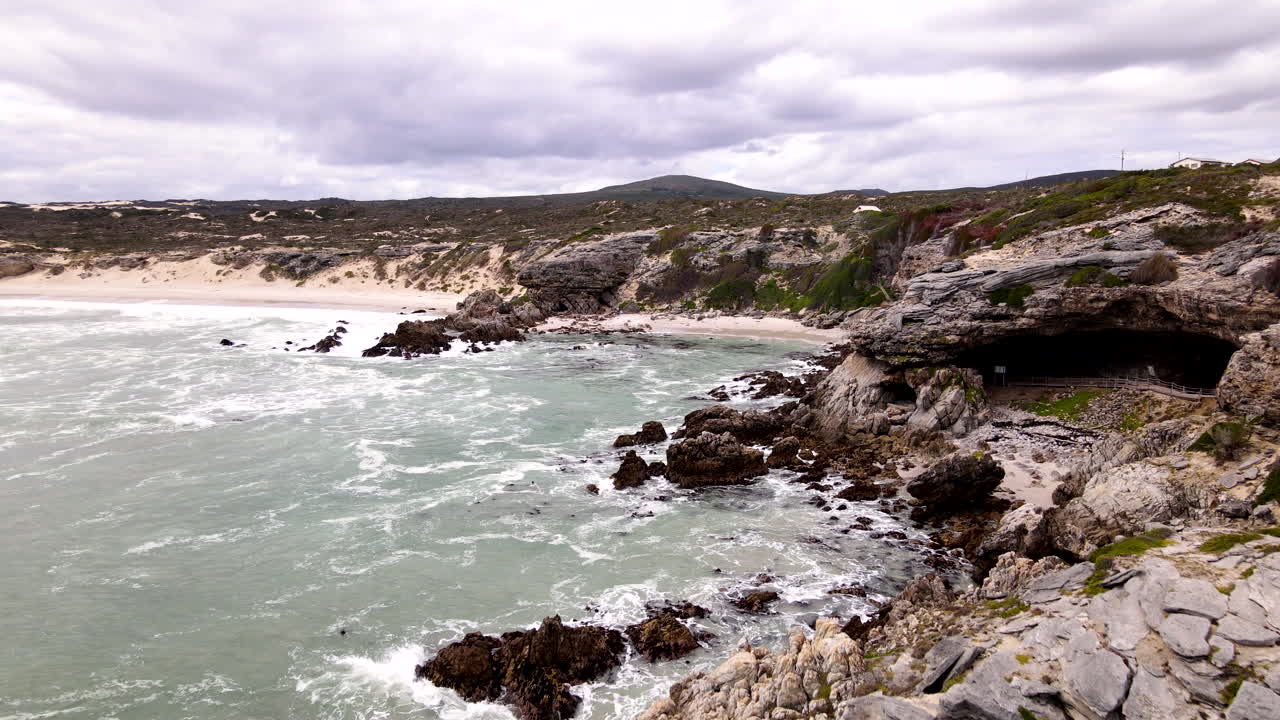 Aerial along Walker Bay coastline past archaeologically important Klipgat Cave