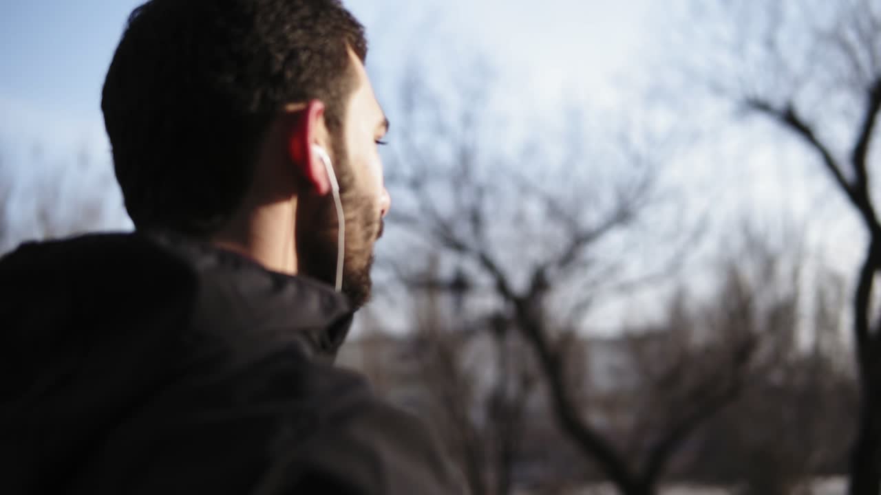 joven hombre atractivo con apariencia caucásica bebiendo agua de una botella de fitness de plástico.