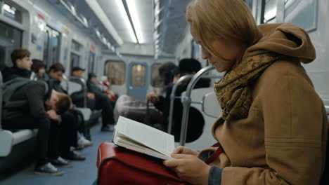 junge frau liest ein buch in der u-bahn