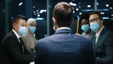 rear view of businessman speaking with his team on a meeting in the office