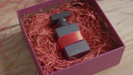 Primer-Plano-De-San-Valentín-Romántico-Presente-De-Regalo-De-Perfume-Envuelto-En-Caja-En-La-Mesa-1