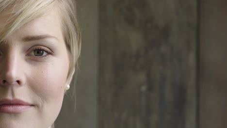 half face portrait of attractive blonde woman looking at camera calm caucasian female beauty on wooden background