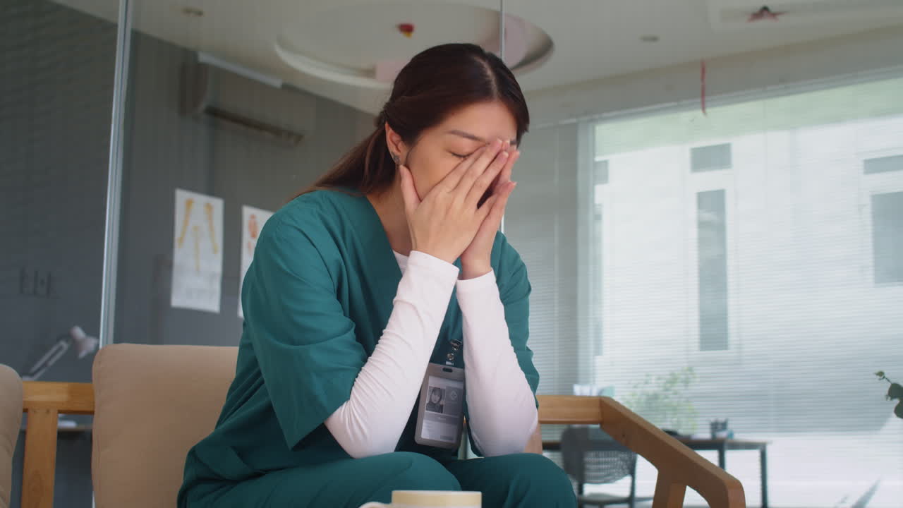 Very Tired Nurse Sitting down on Couch after Long Shift