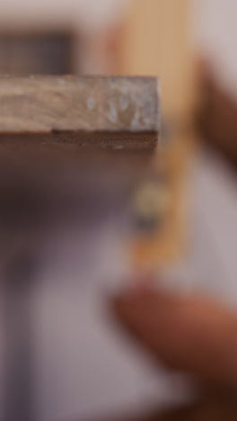 worker removes wooden clamp from workbench board in carpentry workshop closeup. employee prepares tool at workplace. traditional manufacture