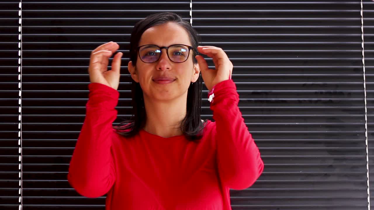Young woman putting on eyeglasses and taking them off, medium close up