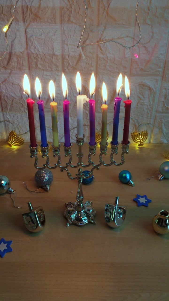 Menorá de Hanukkah con velas encendidas y dreidels