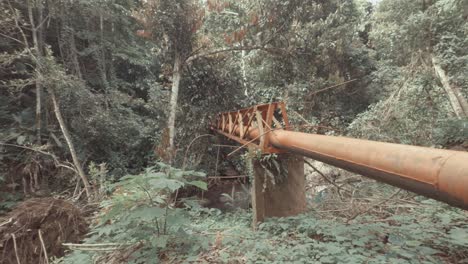 Tubería-Naranja-Corriendo-Sobre-El-Río-En-El-Bosque