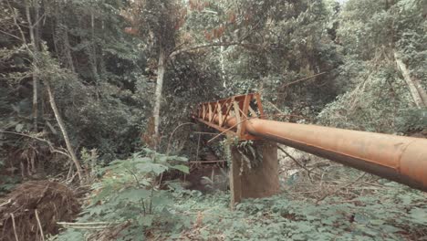 tubo naranja corriendo sobre el río en el bosque