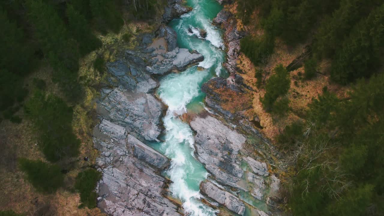 vuelo aéreo sobre un pintoresco e idílico cañón de cascada de río de montaña con agua azul fresca en los alpes austriacos bávaros, fluyendo por un hermoso lecho de río a lo largo de árboles, bosques y rocas desde arriba