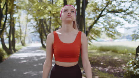 tired athletic fitness sport runner girl taking break after jogging training, finishing race in park