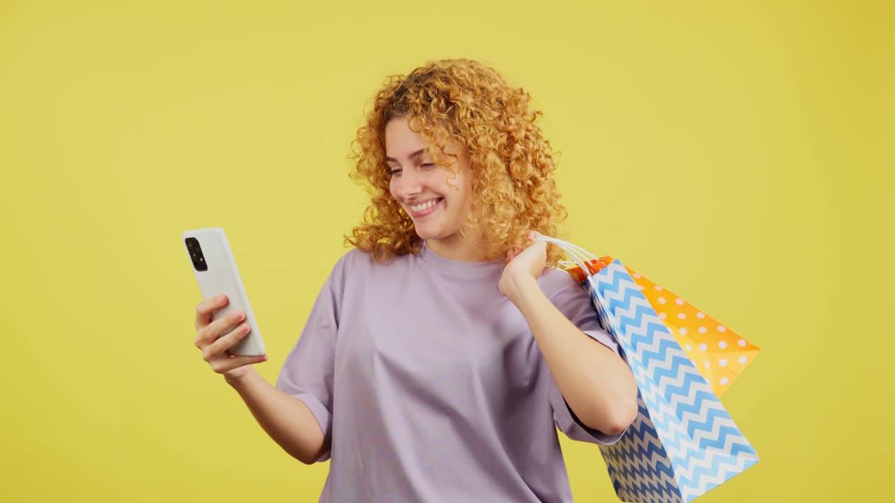 Happy Woman with Shopping Bags Looking at Phone