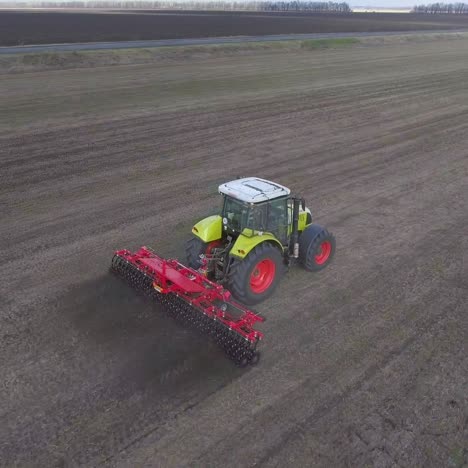 Der-Traktor-Zieht-Ein-Landwirtschaftliches-Gerät-Zum-Eggen-Des-Landes-2