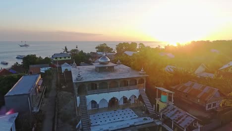 dramatic sunrise over the village and mosque of labuan aji on moyo island indonesia