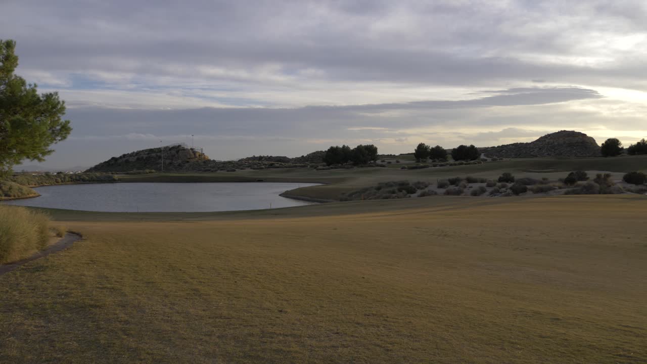 lago en un campo de golf al atardecer