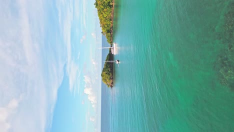 vertical shot - flying on serene seascape of playa bonita with luxury ships in las terrenas, dominican republic