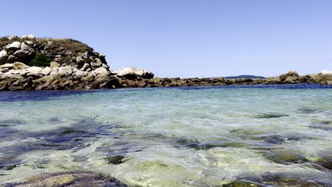 Schwenkaufnahmen-Einer-Felsigen-Küste-Mit-Klarem-Wasser-An-Einem-Sonnigen-Tag-Aus-Sanxenxo